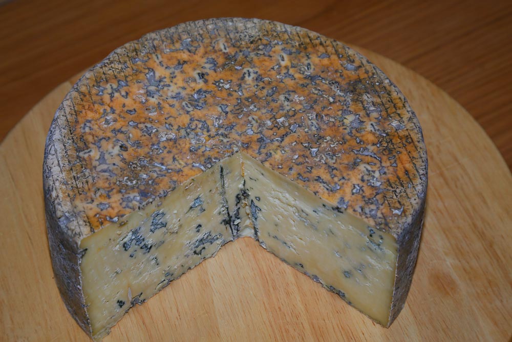 A blue cheese cut open to reveal the blue mould inside.