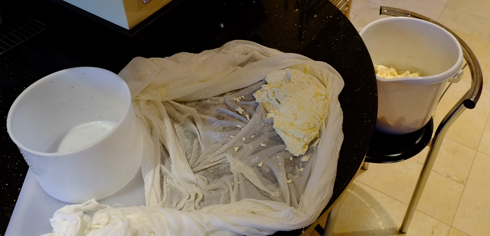 Curds being taken from the draining cloth ready for packing in the mould.