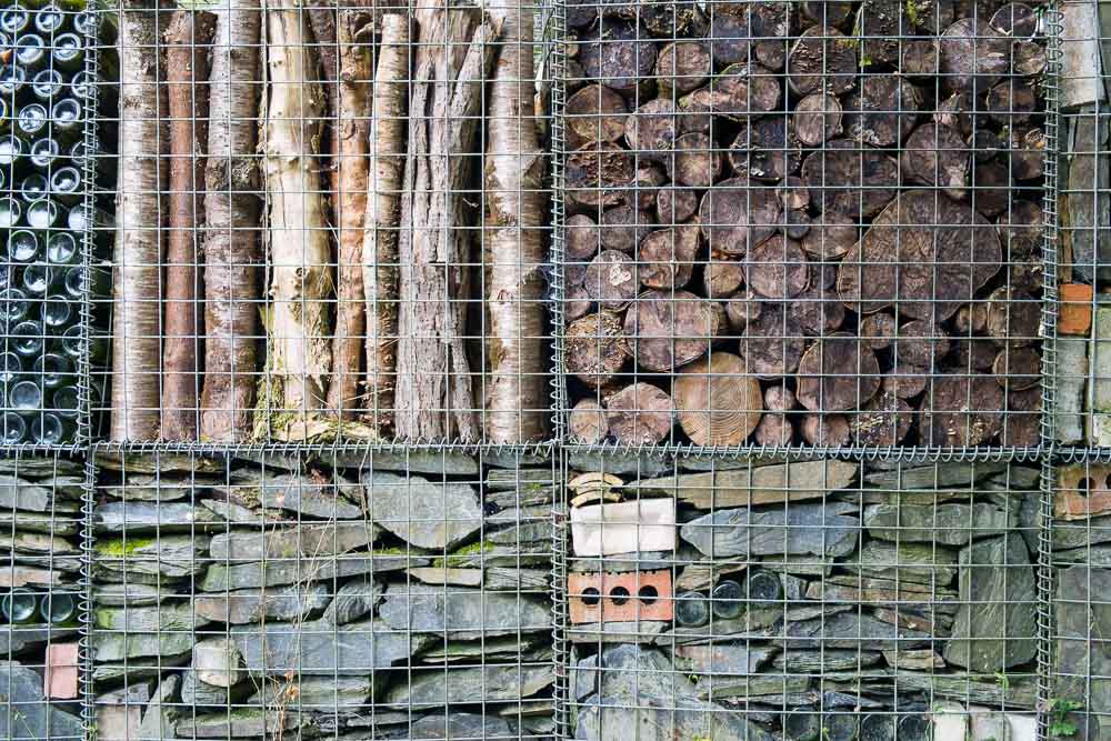 Wire cages (gabions) containing logs, bottles, stones and bricks.