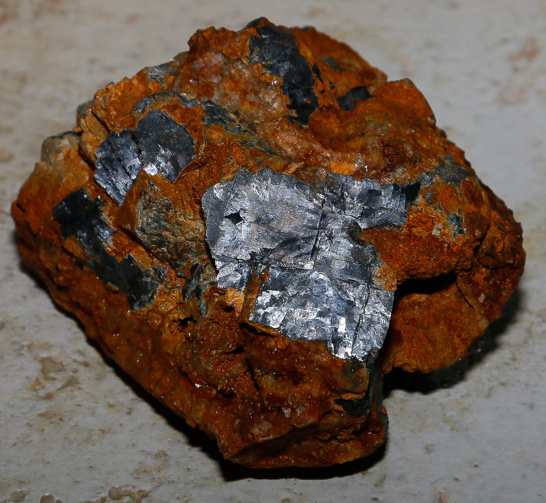 A piece of lead ore showing silvery lead crystals and brown ochre