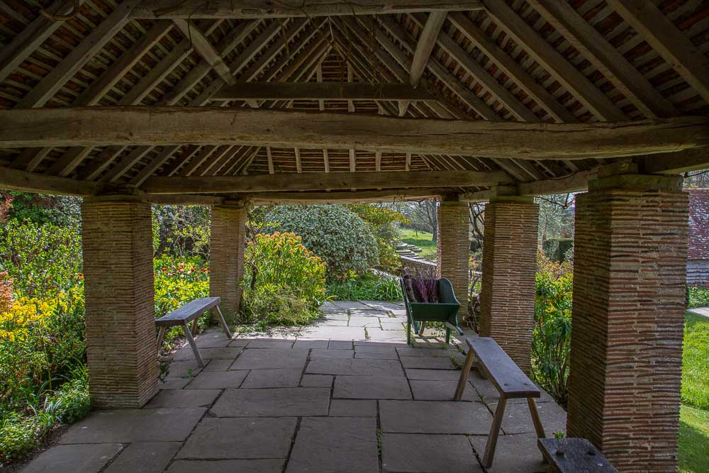 The underside of a terracotta tiled pergola with columns supporting the roof made from tiles and mortar