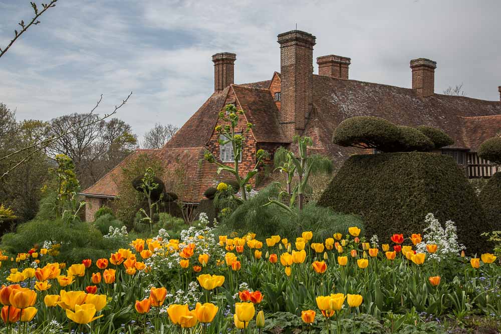 Great Dixter House with yellow and orange tulips and giant fennel in the foreground.
