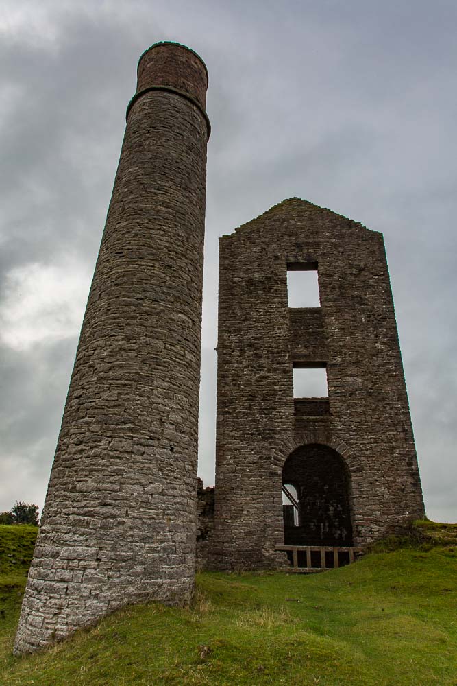 A derelict chimney and winding house that once contained a steam engine