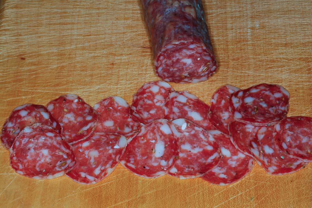 Sliced salami on a wooden board.