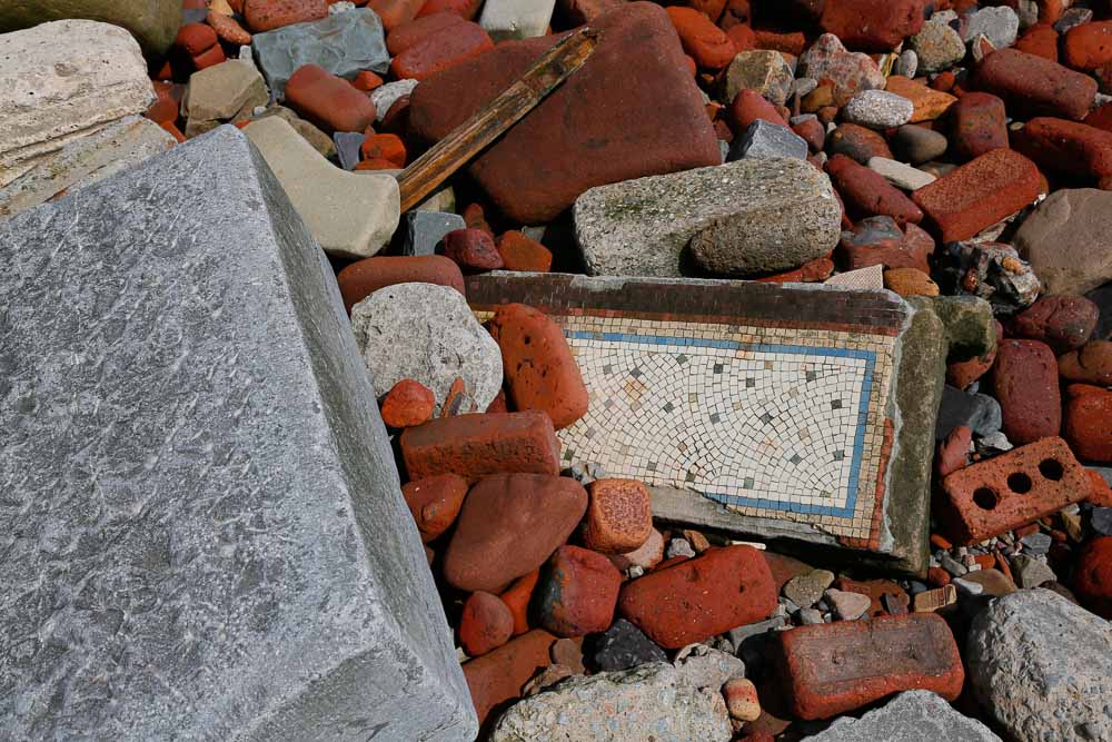 Building rubble with bricks, stonework and a piece of mosaic tiled floor