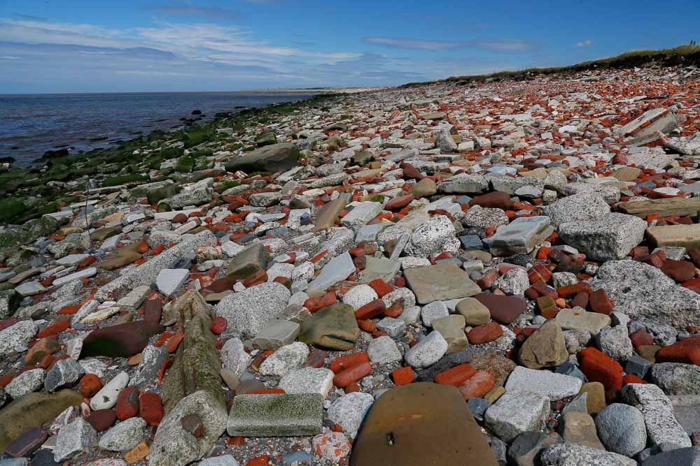A beach entirely covered in bricks and stones as far as the horizon